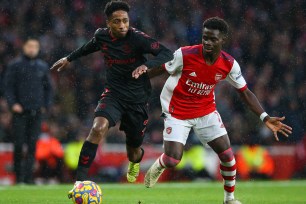 Kyle Walker-Peters of Southampton holds off the challenge from Bukayo Saka of Arsenal