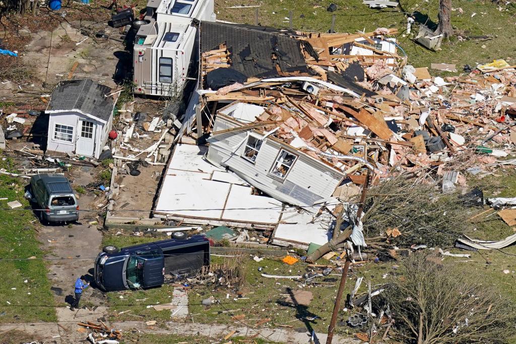 In this aerial photo, people walk amidst destruction from a tornado that struck Tuesday night in Arabi, La., Wednesday, March 23, 2022.