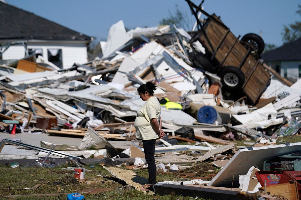 Bertelina Martinez, who lives nearby and her son lives across the street, looks over destruction after a tornado struck the area in Arabi, La., Wednesday, March 23, 2022. 