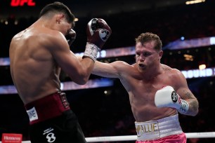 Canelo Alvarez, right, of Mexico, throws a punch against Dmitry Bivol, of Kyrgyzstan, during a light heavyweight title fight, Saturday, May 7, 2022, in Las Vegas.