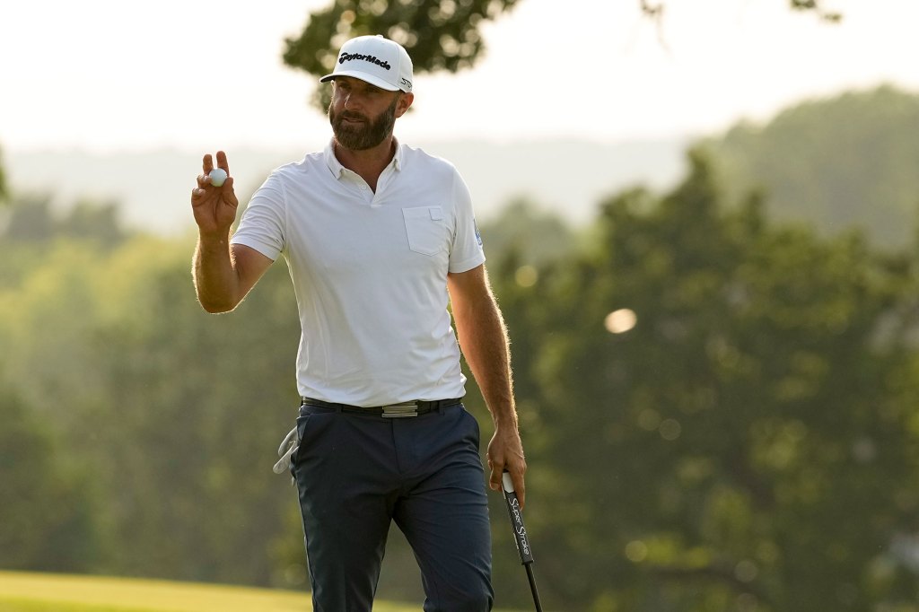 Dustin Johnson waves after making a putt on the 18th hole 