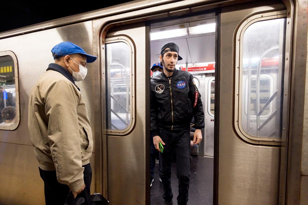 People enter and exit a New York City subway car.