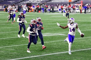 Stefon Diggs #14 of the Buffalo Bills reacts as he runs into the end zone for a touchdown as Jonathan Jones #31 and J.C. Jackson #27 of the New England Patriots give chase.