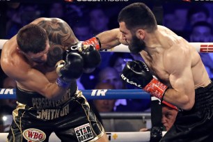 Artur Beterbiev punches Joe Smith Jr. during his victory in the men's lightweight title unification bout.