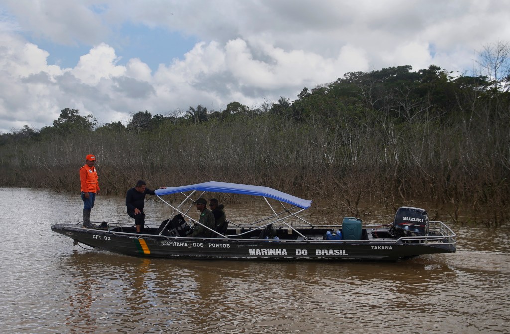 A volunteer diver helps Navy men in the search of Dom Phillips and Bruno Pereira at the Javari Valley Indigenous territory on June 9, 2022.