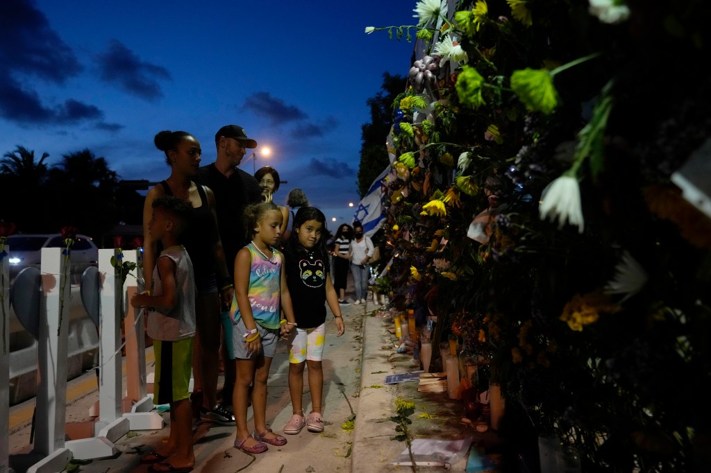 Well-wishers visit a makeshift memorial for the victims of the Champlain Towers South condo building collapse.