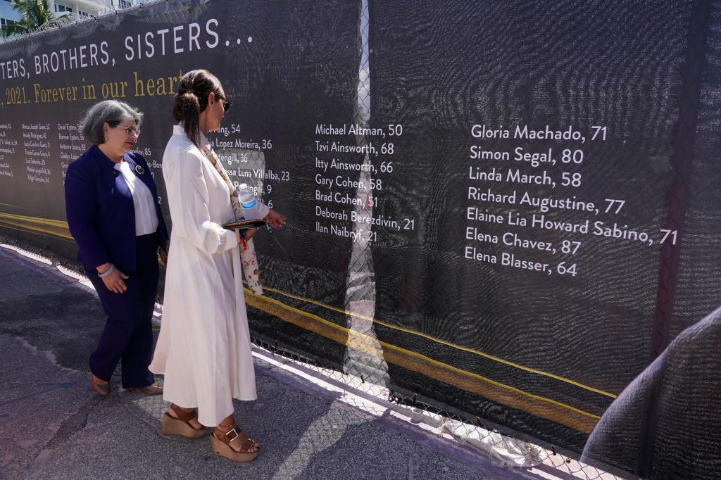 Ronit Naibryf, right, shows Miami-Dade County Mayor, Daniella Levina Cava, the name of her son on a banner to remember the victims in Surfside.