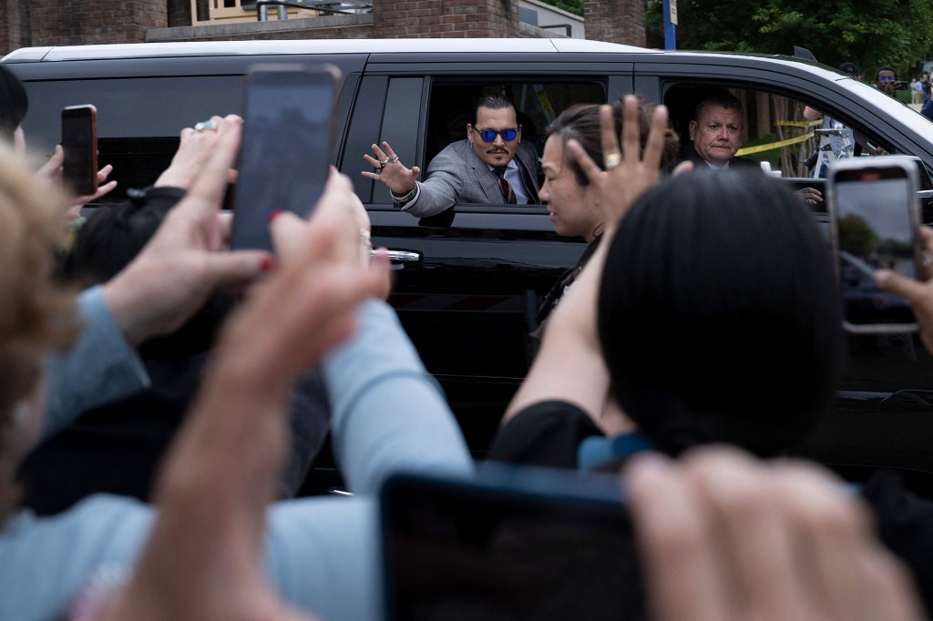 Johnny Depp greets his fans while leaving court in Fairfax, Virginia.