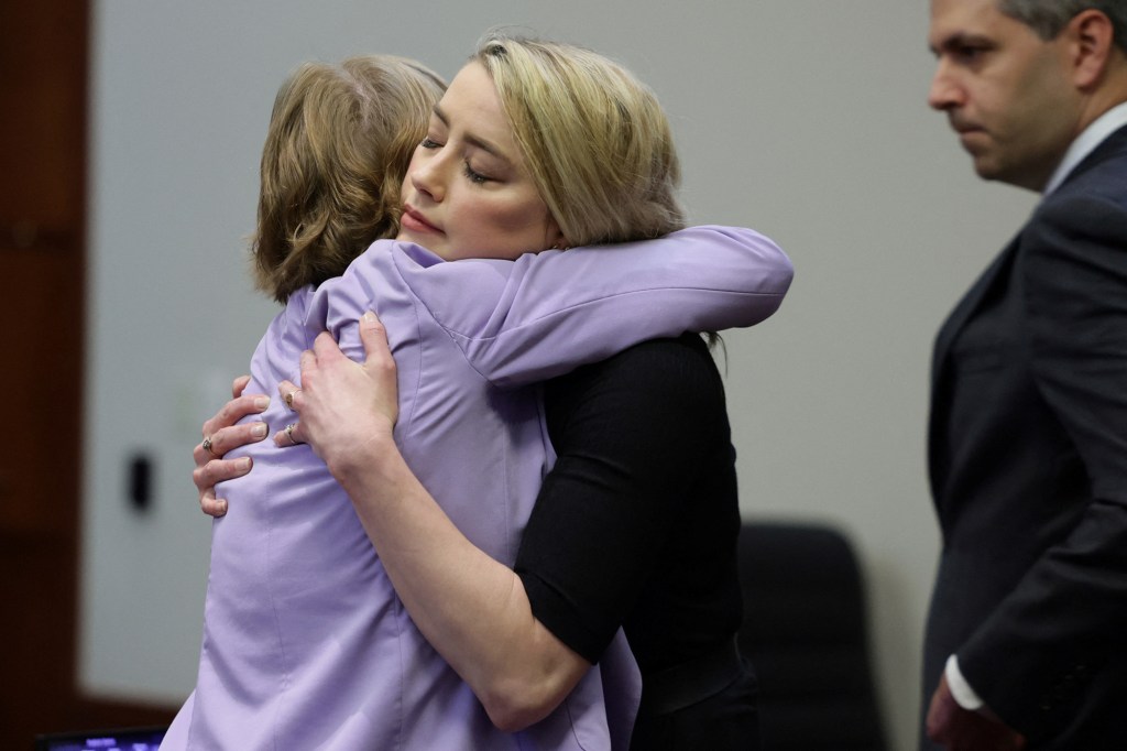 Actor Amber Heard hugs her lawyer Elaine Bredehoft.