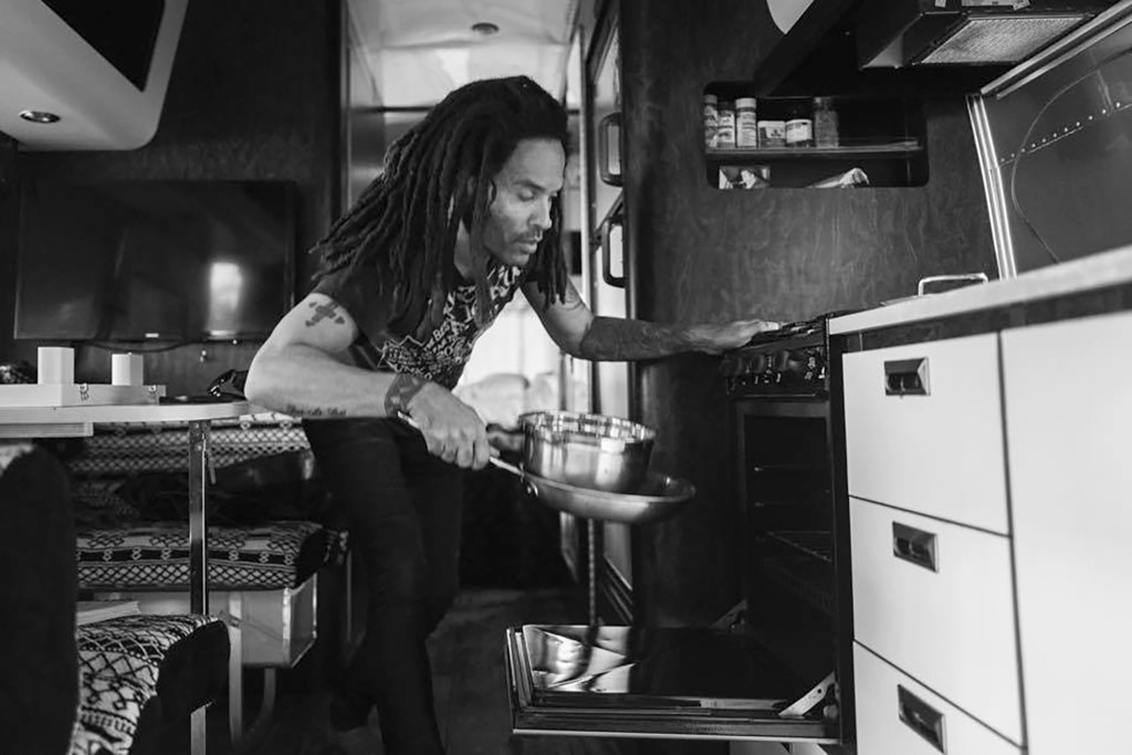 Lenny Kravitz storing pots and pans in the oven of the trailer. 