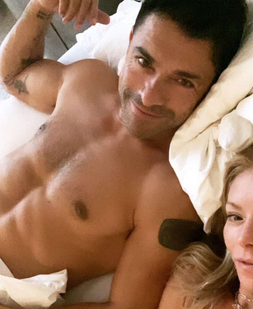 Shirtless Mark Consuelos in bed with wife Kelly Ripa.