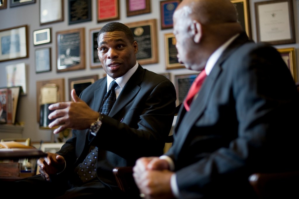 Walker chats with the late Georgia Rep. John Lewis in his Trump-appointed role as the co-chair of the President’s Fitness Council.