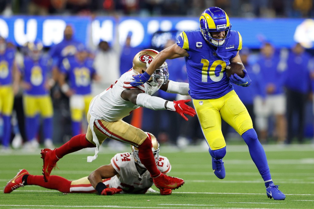 Cooper Kupp #10 of the Los Angeles Rams runs with the ball as Fred Warner #54 and K'Waun Williams #24 of the San Francisco 49ers defend in the NFC Championship Game at SoFi Stadium on January 30, 2022 in Inglewood, California. 