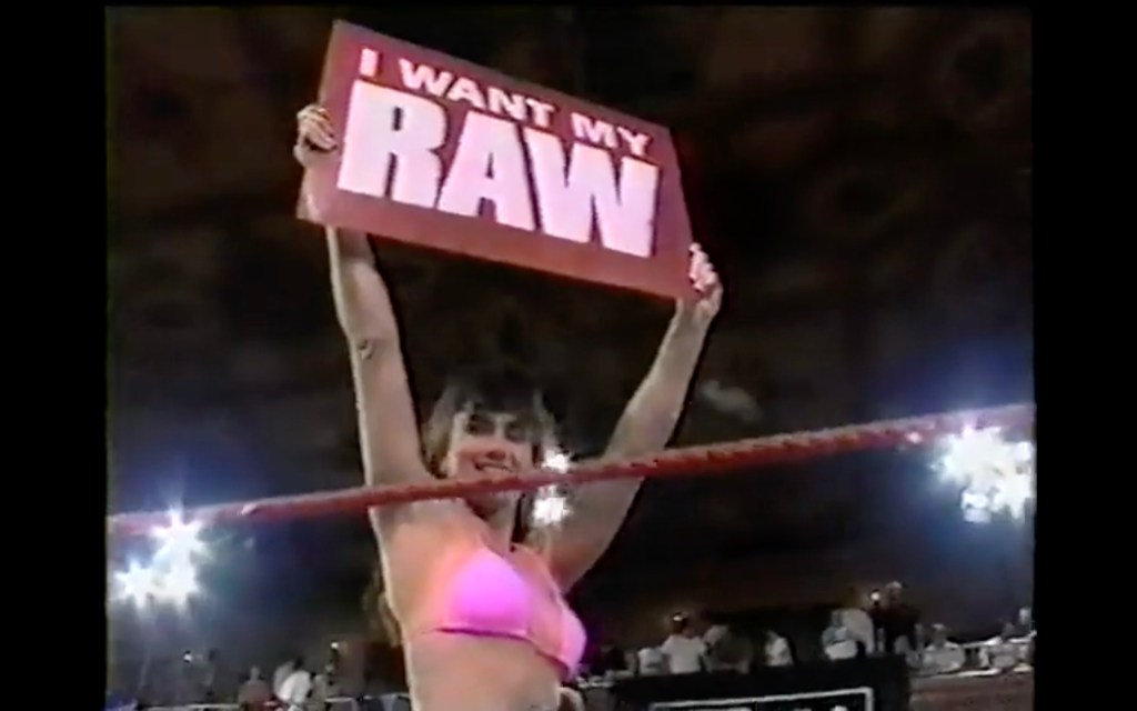 Klarides holding up a sign in the ring during a a Raw event.