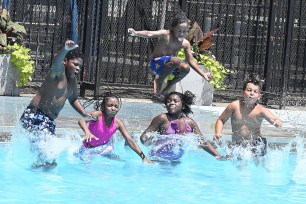 Group of children splash in a pool to beat the heat