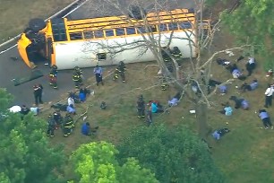 Photo shows the yellow bus on its side as first responders converge on the scene.