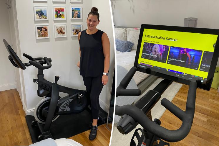 Woman wearing black workout outfit standing in front of a SoulCycle at-home bike