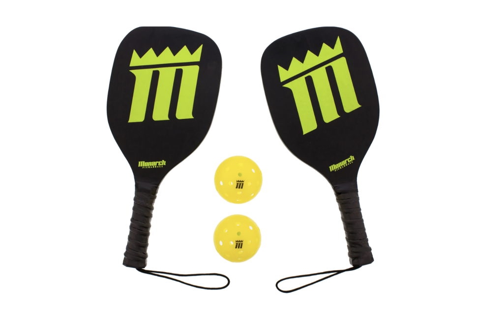 Two black and green pickleball paddles and two yellow balls 