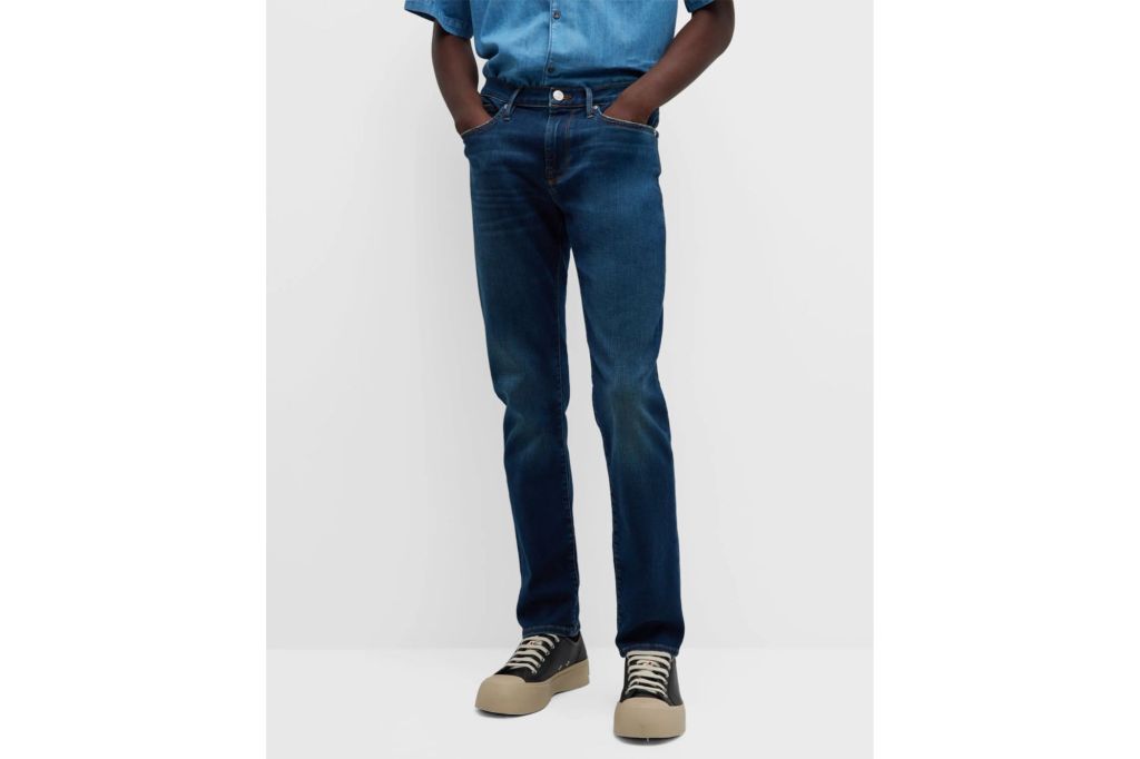 Model in blue shirt and slim fit dark denim jeans.