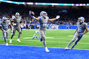 Amon-Ra St. Brown #14 of the Detroit Lions celebrates after catching a touchdown as the time expired to defeat the Minnesota Vikings 29-27 at Ford Field on December 05, 2021 in Detroit, Michigan.