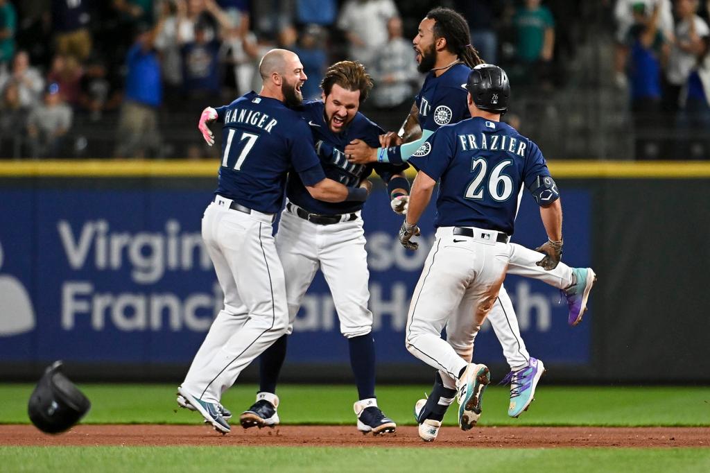 Mitch Haniger #17, Adam Frazier #26, aJ.P. Crawford #3 celebrate with Luis Torrens #22 of the Seattle Mariners after his game winning walk-off single against the New York Yankees at T-Mobile Park on August 09, 2022 in Seattle, Washington. The Seattle Mariners won 1-0 in 13 innings.