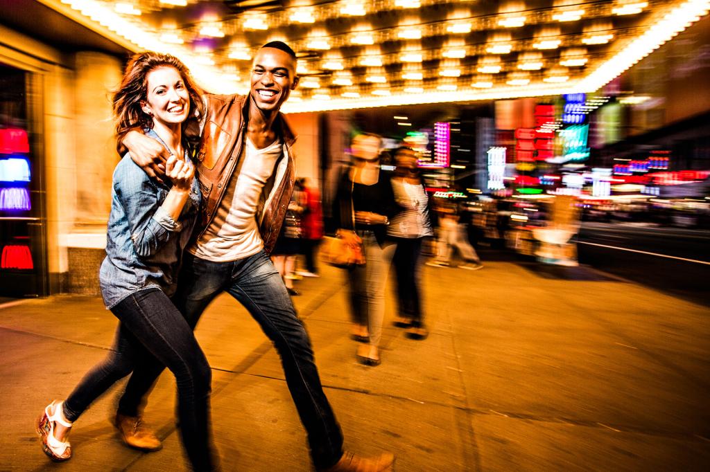 Couple having fun at night on Broadway, New York City.