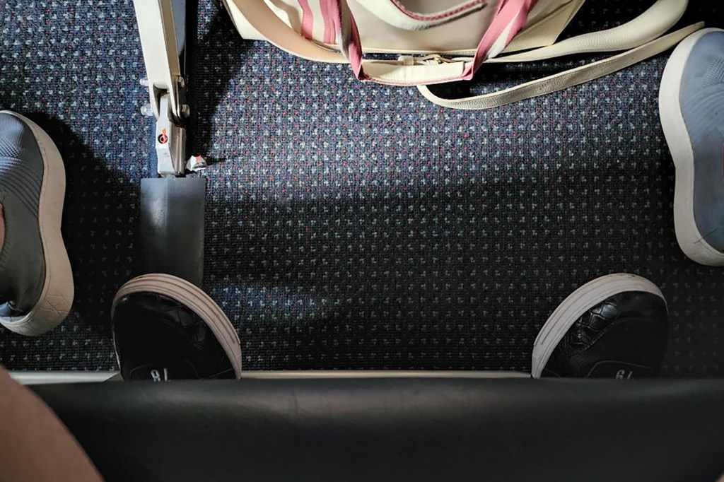 Photo of passenger’s feet under seat.