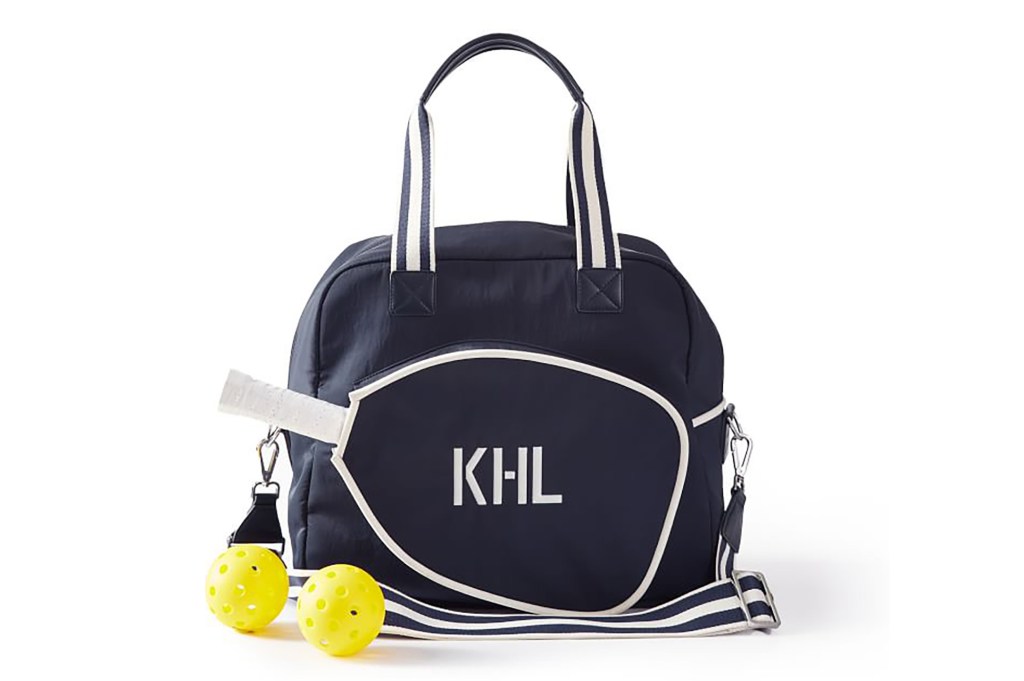 A navy blue pickleball bag with a monogram on it in white 