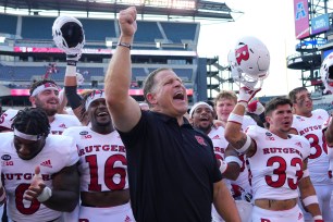 Coach Greg Schiano celebrates with his Rutgers team after their 16-14 win over Temple.