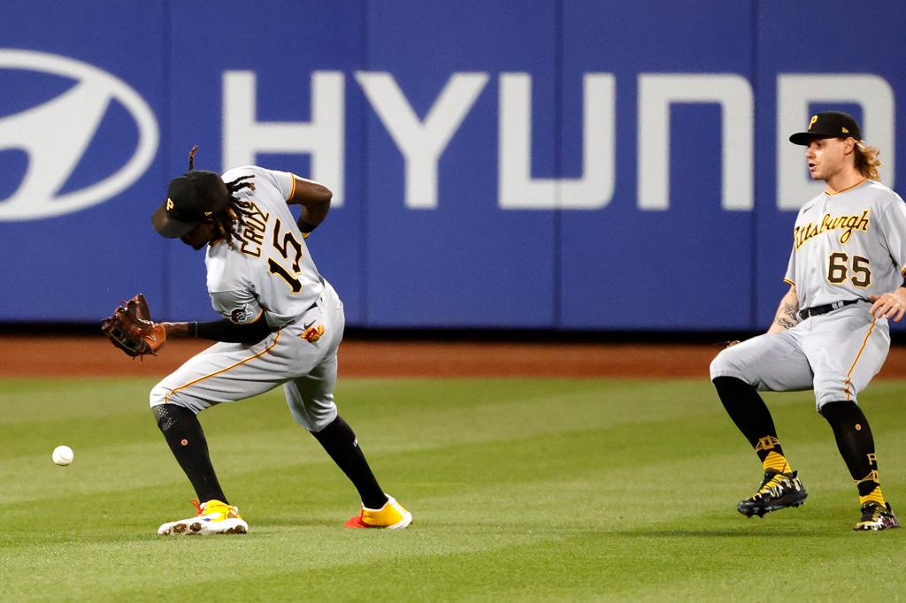 Pirates shortstop Oneil Cruz, left, can't catch Brandon Nimmo’s fly ball to left field in the top of the seventh, allowing a run to score.