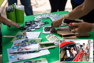 Community members collect stickers, coasters, poster fans, tee shirts, bottle openers and other free items at the grand opening ceremony for Fountain Row, Bowling Green's new entertainment destination center, at Fountain Square Park in downtown Bowling Green, Ky., on July 15.