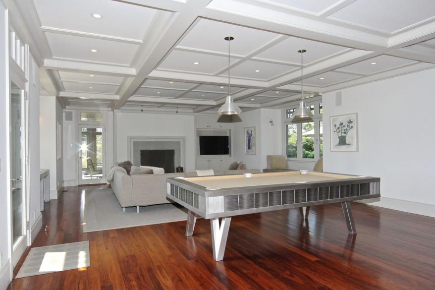 Another living room has a large pool table.