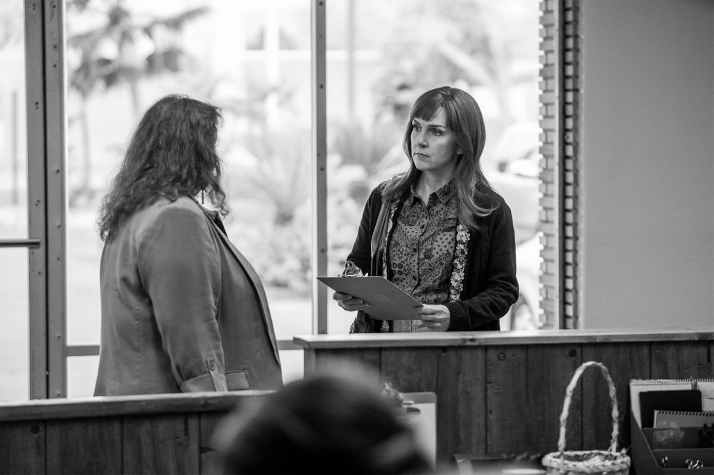 Rhea Seehorn as Kim Wexler in "Better Call Saul." It's a black-and-white photo and Kim is standing in an office holding a clipboard.