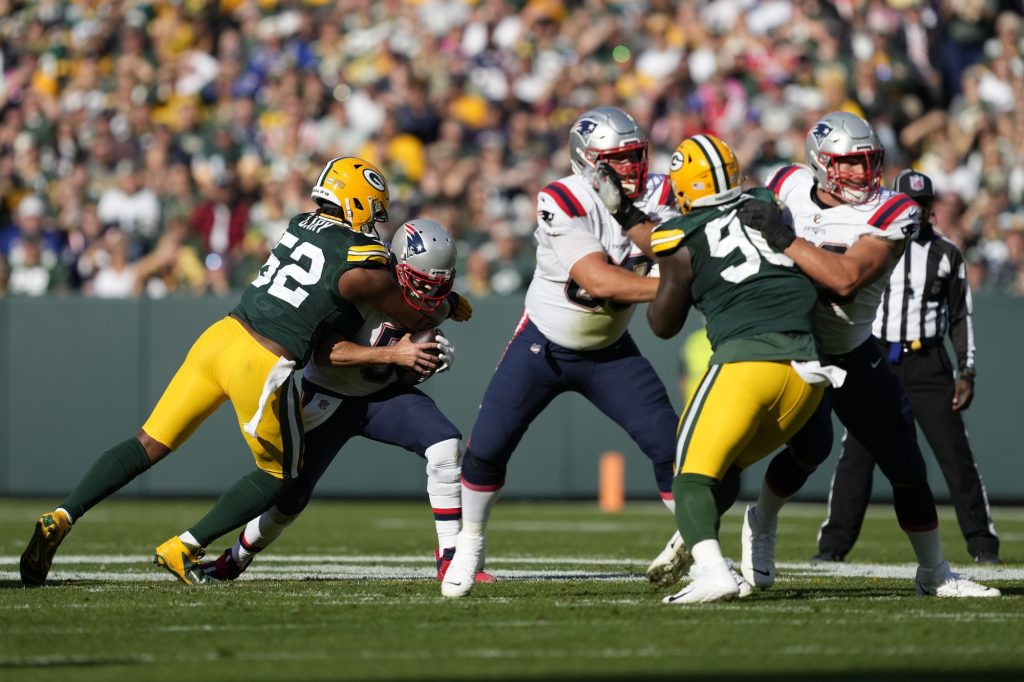 Rashan Gary #52 of the Green Bay Packers sacks Brian Hoyer #5 of the New England Patriots during the first quarter at Lambeau Field on October 02, 2022 in Green Bay,