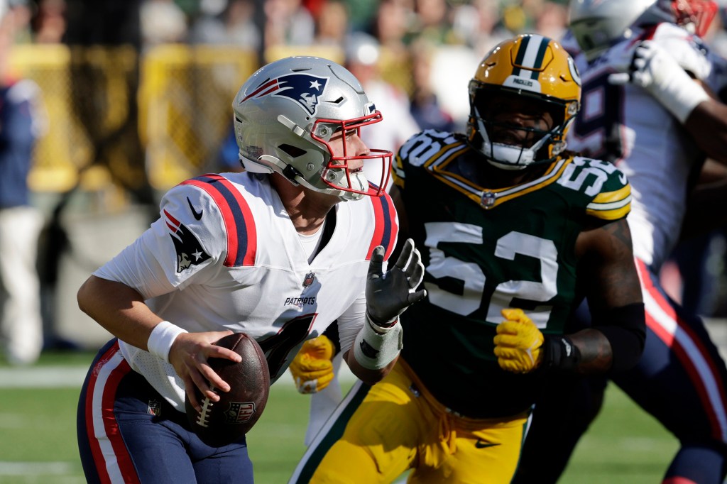 Patriots quarterback Bailey Zappe runs from Packers linebacker Rashan Gary during the first half on Oct. 2, 2022.