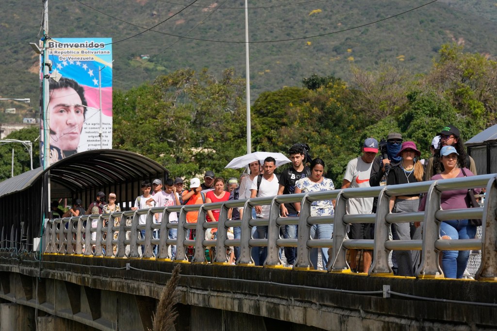 Pedestrians use the Simon Bolivar International Bridge to cross between San Antonio, Venezuela and Cucuta, Colombia, Monday, Sept. 26, 2022. Vehicles with merchandise also crossed the bridge in a ceremonial act to seal the resumption of commercial relations between the two nations. (AP Photo/Fernando Vergara)