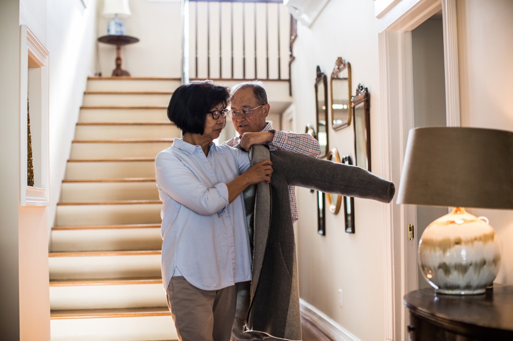 Senior man helping wife with coat