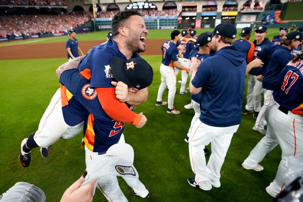 Jose Altuve gets a big hug as the Astros celebrate after their 4-1 World Series-clinching win over the Phillies.