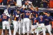 Yordan Alvarez (No. 44) is mobbed by teammates after hitting a three-run homer in the sixth inning of the Astros' 4-2 World Series-clinching win over the Astros.