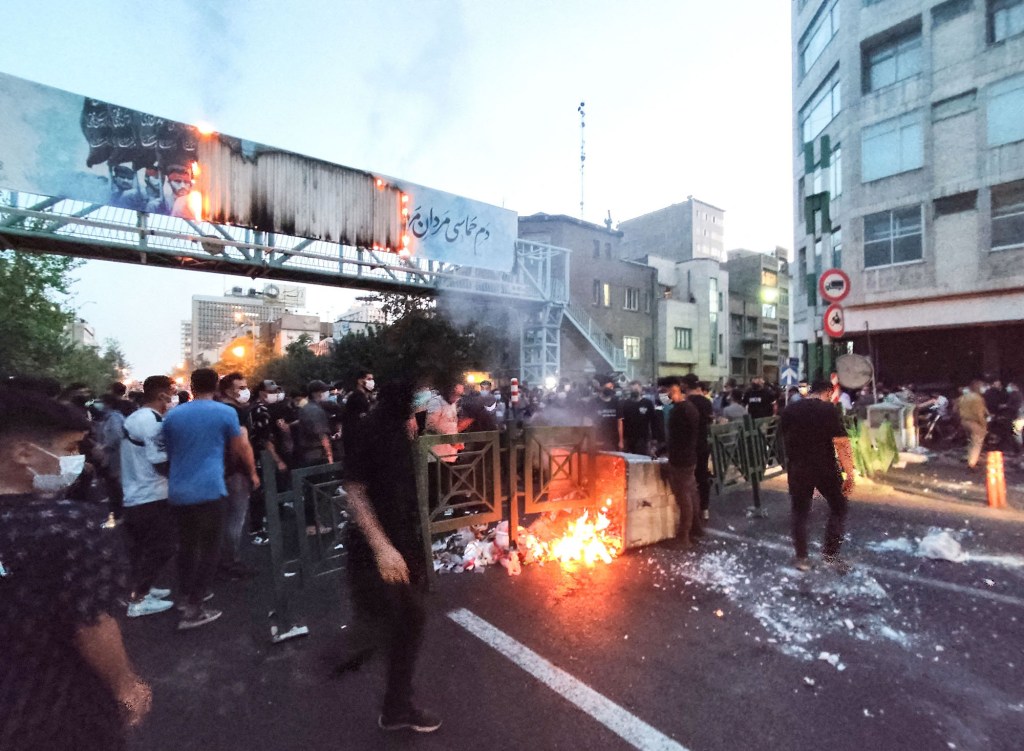 Protesters burn a trash can during a rally in Tehran for Amini in late September, just days after she died.