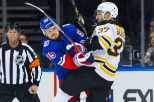Ryan Lindgren hits Patrice Bergeron during a Rangers-Bruins game on Nov. 3, 2022.