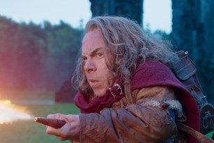 Warwick Davis in "Willow" leaning and looking worried.