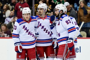 Adam Fox #23, Chris Kreider #20, and Mika Zibanejad #93 of the New York Rangers huddle during the third period against the Pittsburgh Penguins at PPG PAINTS Arena on February 26, 2022 in Pittsburgh, Pennsylvania.