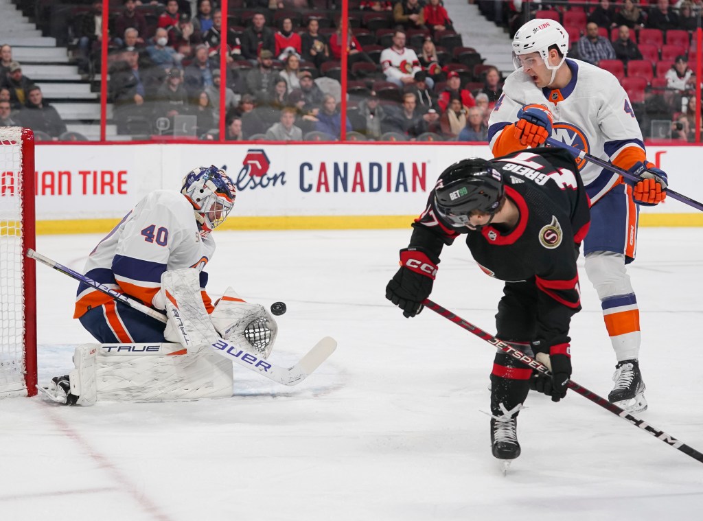 Semyon Varlamov #40 of the New York Islanders makes a save against the Ottawa Senators as Ridly Greig #17 of the Ottawa Senators in his NHL debut battles for position against Samuel Bolduc #4 at Canadian Tire Centre on January 25, 2023 in Ottawa, Ontario, Canada. 
