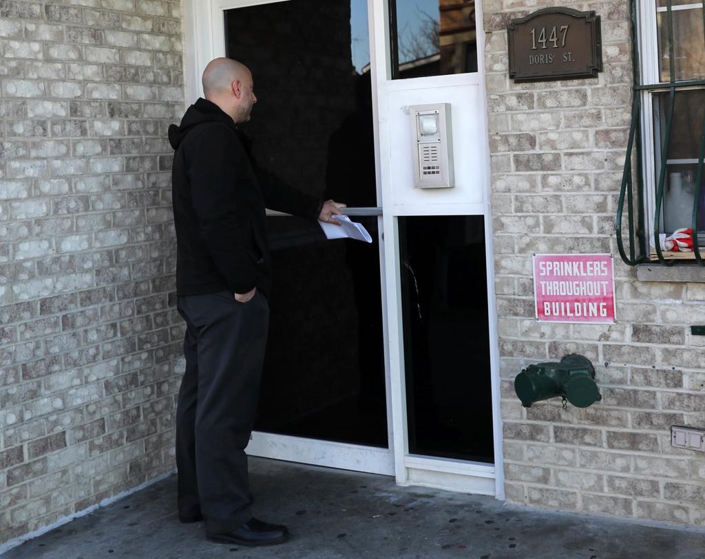 A detective responds to the apartment door at 1447 Doris Street in the Bronx.