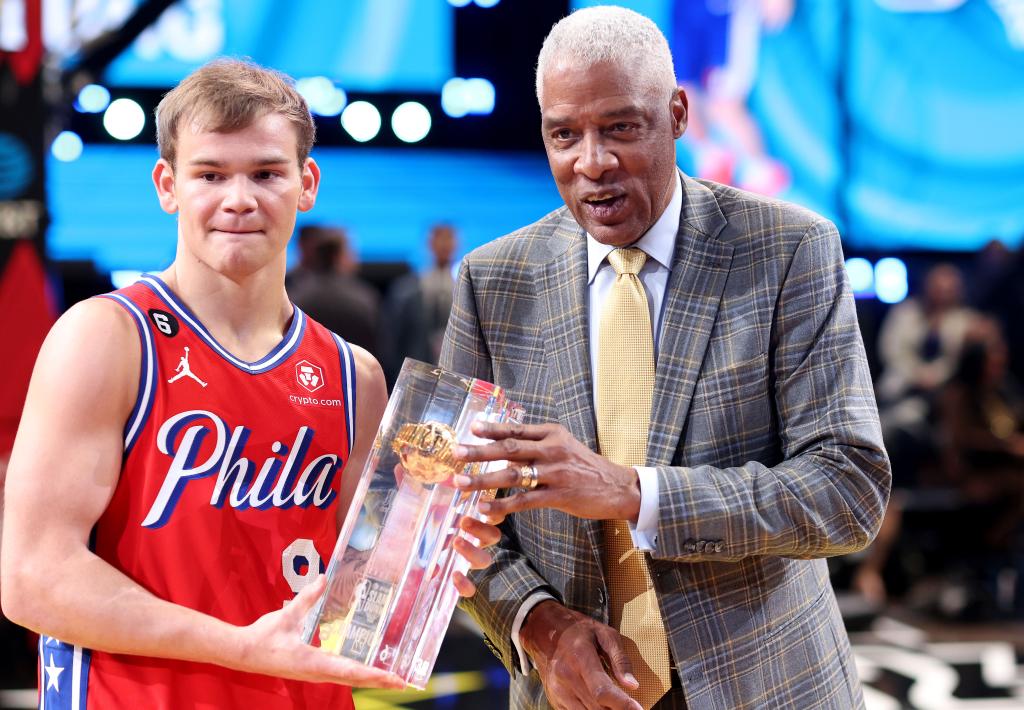 Mac McClung accepts the trophy from Julius Erving after winning the Slam Dunk Contest.