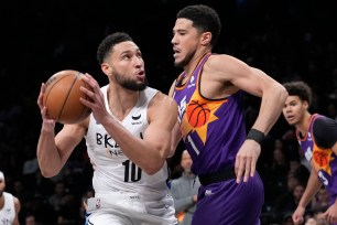 Nets guard Ben Simmons (10) drives against the Suns' Devin Booker on Feb. 7, 2023.