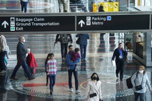 A mix of masked and unmasked travelers make their way through Ronald Reagan Washington National Airport.