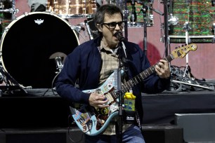 Weezer frontman Rivers Cuomo rocks out onstage.