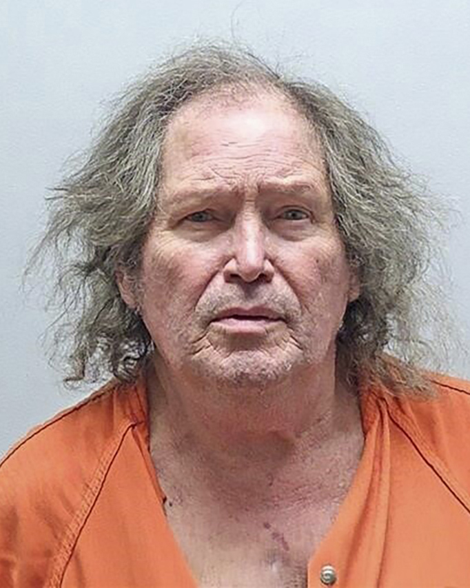 A mug shot of Fred Bandy. He is wearing an orange jumpsuit and has disheveled grey hair.